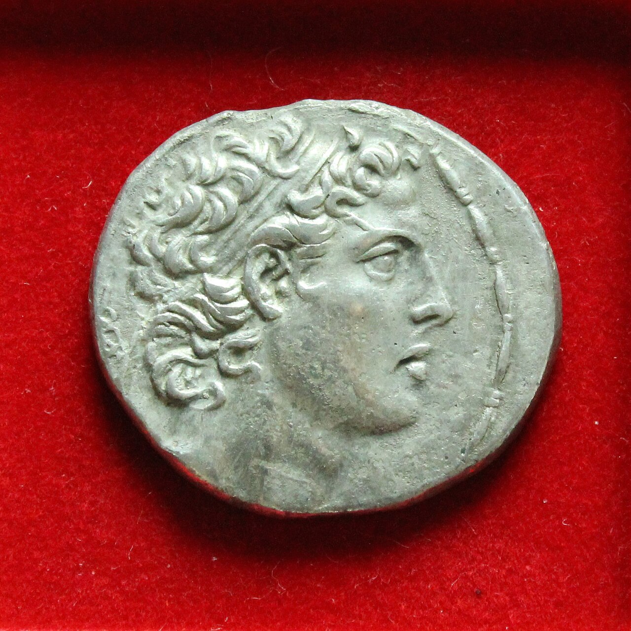 Tetradracma de Antíoco IV Epífanes (reinado 175–164 a. C.), acuñado en Ake-Ptolemaida. Retrato del rey seléucida cuyas medidas contra el culto del Templo describe 1 Macabeos 1; la moneda no documenta esas medidas.